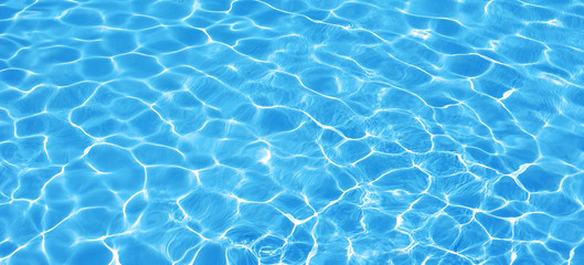 Fototapeta na wymiar Water background, ripple and flow with waves. Summer blue swiming pool pattern. Sea, ocean surface. Overhead top view with place for text. Panoramic banner