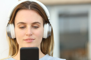 Woman with headphones listening to music on phone