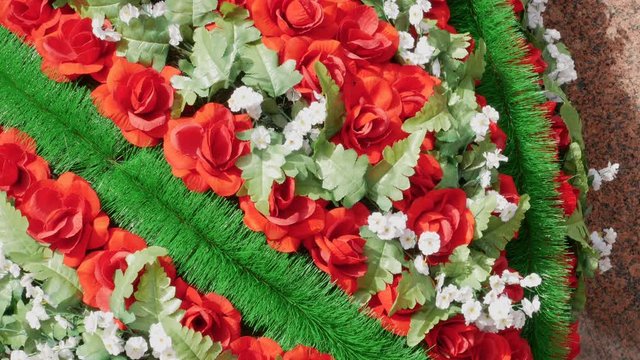 A wreath of red flowers on the tomb.
