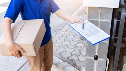 Delivery man in blue uniform handing parcel box for client  signing checklist after confirm receiving package.