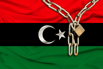 iron chain and lock on the silk national flag of libya with beautiful folds, the concept of a ban...