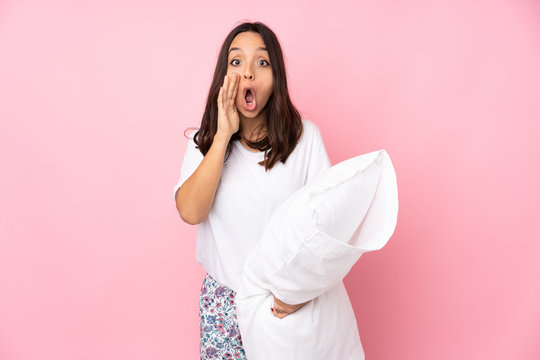 Young woman in pajamas isolated on pink background shouting and announcing something