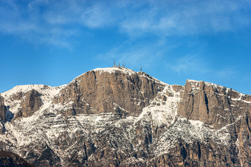 Fototapeta na wymiar Peak of the Paganella or cima Roda (2125 m), snow caped Alps with the antennas of the weather station, seen from the Trento city, Adige Valley, Trentino Alto Adige, Italy, Europe