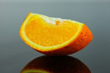 Orange slice and reflect on the dark background