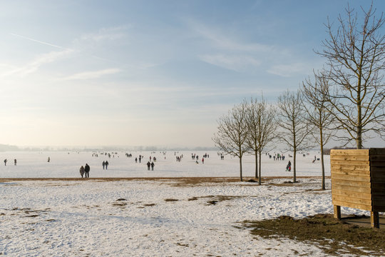 Spaziergänger laufen über das gefrorene Eis des Altmühlsees im Fränkischen Seenland. Im Winter friert der See teils zu. Nur selten ist er wie hier begehbar. Der Altmühlsee ist in Mittelfranken Bayern.