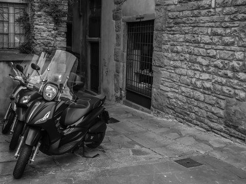 modern motorcycles on an old street, black and white photo, Bergamo, Italy