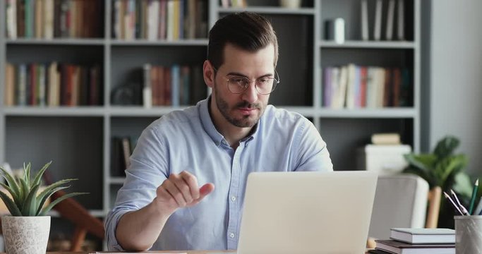 Stressed business man feels frustrated by data loss using laptop at work. Shocked male user looks at computer screen reads bad news, has unexpected online website problem sitting at home office desk.