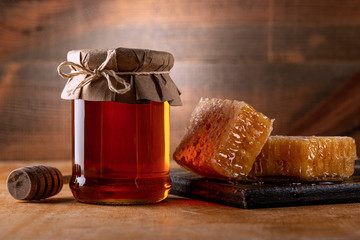 Honey background. Sweet honey in the comb, glass jar.