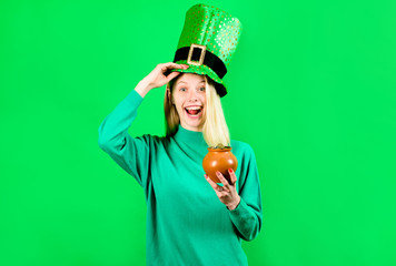 Green top hat. Blonde girl in Leprechaun costume holds pot with gold. Leprechaun. Pot with gold....