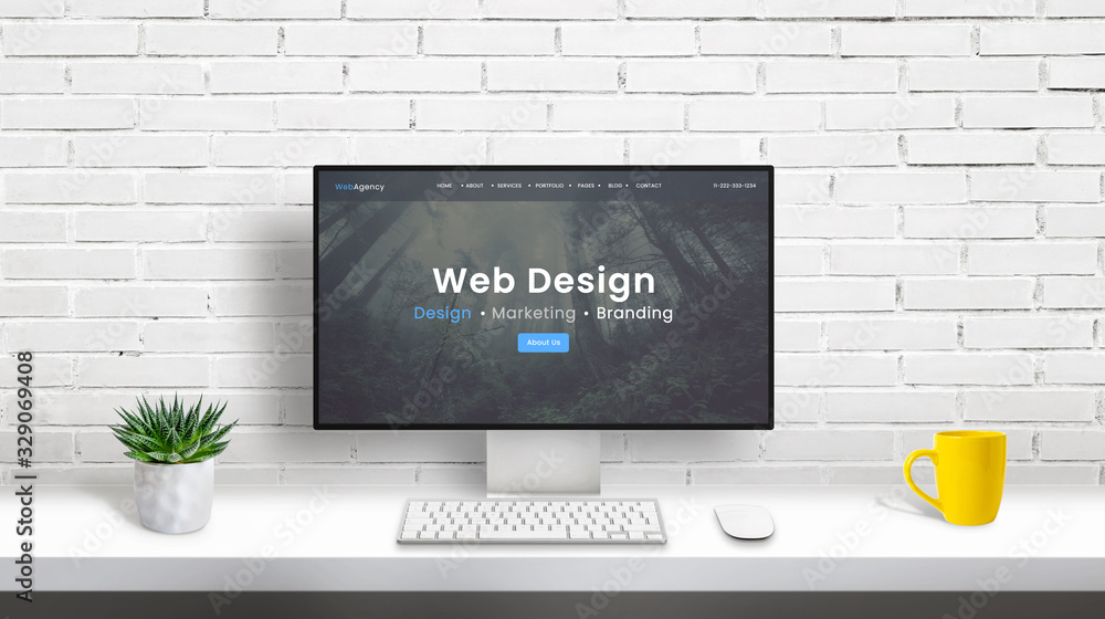 Aufkleber Web design studio concept with computer display and web design agency web page. clean desk with plant, keyboard, mouse and coffee mug. White brick wall in background