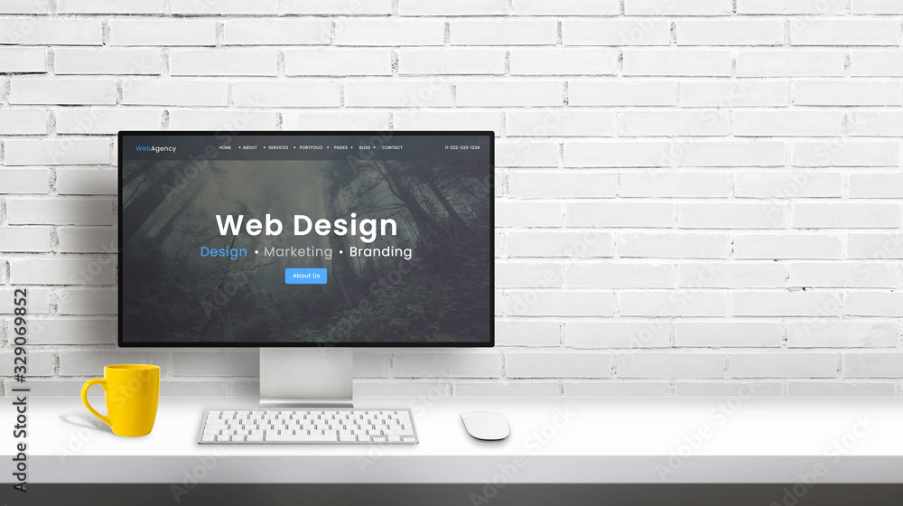 Fototapete Web design studio computer display with agency portfolio web page. Copy space beside on white brick wall