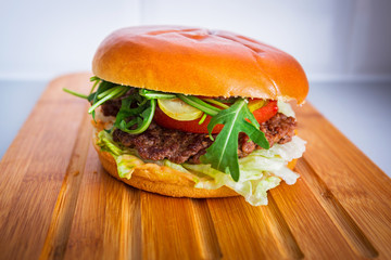 Homemade hamburger on wooden cutting board
