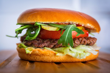 Homemade hamburger on wooden cutting board