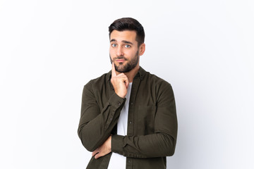 Young handsome man with beard over isolated white background Looking front