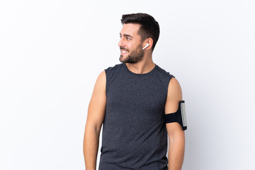 Fototapeta premium Young sport handsome man with beard over isolated white background looking side