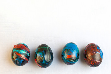 Painted into abstract universe blue flowing colors eggs. Easter preparations, eggs covered in paints with copy space..