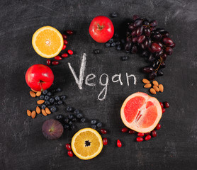 Obraz na płótnie Canvas Mixed healthy fruit over a blackboard background. Concept pf vegan and genuine fruit