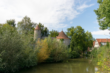 Durch Dinkelsbühl fließt der Fluss Wörnitz. Dinkelsbühl ist eine Stadt in Mittelfranken im Freistaat Bayern. Touristen aus der ganzen Welt besuchen Dinkelsbühl aufgrund der mittelalterlichen Altstadt.