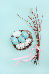 Easter background with Easter eggs in bird nest on blue background