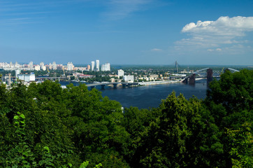 Fototapeta na wymiar Panorama of the city of Kiev, view of the Dnieper River and forest. Construction of a new arch bridge over the river. The capital of ancient Russia. Kyiv, Ukraine, July 4, 2015