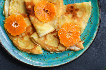 crepes with citrus, jam and berries (thin pancakes, mandarin, blueberry) menu concept. background. top view. copy space