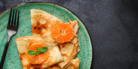 crepes with citrus, jam and berries (thin pancakes, mandarin, blueberry) menu concept. background. top view. copy space