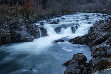 Long exposure shot of the waterfalls in Glen Orchy near Bridge of Orchy in the Argyll region of the highlands of Scotland during winter whilst the river is flowing fast from rainfall