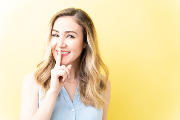 Fototapeta premium Gorgeous Smiling Woman Asking To Keep Silence