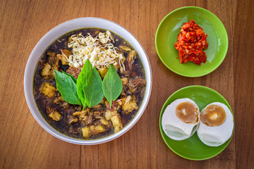 Rawon or beef black soup is one of Indonesian traditional food. made from beef, keluak (pangium edule), bean sprouts and various kinds of seasonings. rawon served with salted duck egg and chili