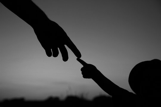 Silhouette The Parent Holds The Hand Of A Child