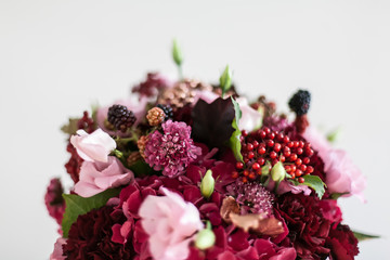 Blumenstrauß mit Beeren in Bordeaux und Rot