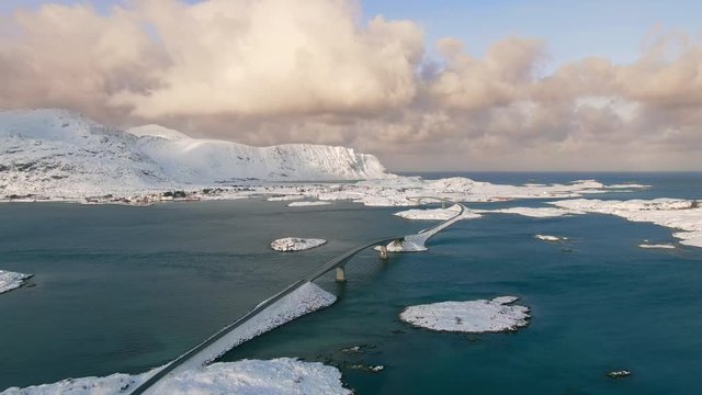 lofoten aerial view of snowy landscape drone flying over fredvang bridge crossing the sea norway