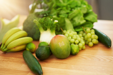 Fresh green fruit and vegetables on wooden counter