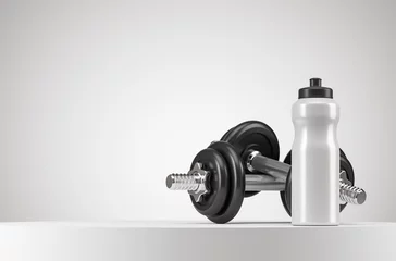 Fotobehang White fitness bottle and two dumbbells on the white podium with copy space. Sport healthy lifestyle concept. © Foxstudio