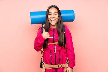 Young mountaineer Indian girl with a big backpack isolated on pink background making phone gesture