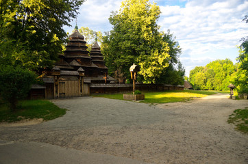 A green garden in the backyard with a wooden hut and lawn. Beautiful forest with a glade and a country house. Countryside lente housing, holiday home. Wooden Old Russian Architecture.