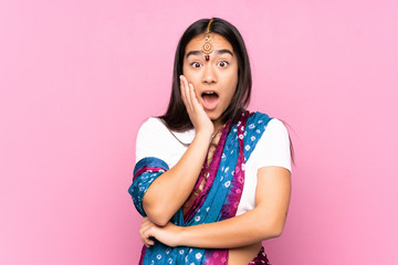 Young Indian woman with sari over isolated background surprised and shocked while looking right