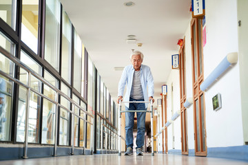 asian old man walking with a walker in nursing home