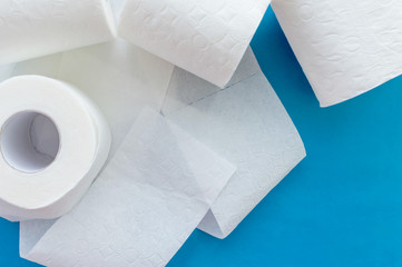 Rolls of white toilet paper on a blue background. Close up. The view from the top.