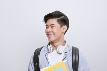 Portrait of young asian student holding books isolated over white background