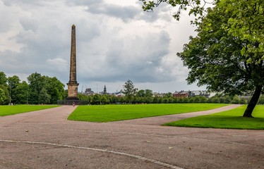 Glasgow Green park in Scotland with trees, perfectly cut grass and the Nelson Monument