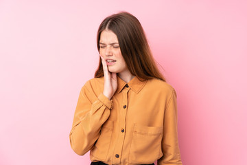 Ukrainian teenager girl over isolated pink background with toothache