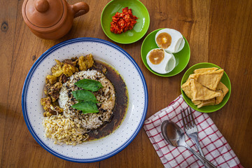 Nasi rawon or beef black soup is  is one of Indonesian traditional food. served with salted duck egg, bean sprouts, fried tofu and sambal (chili). top view