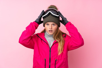 Ukrainian teenager skier girl with snowboarding glasses over isolated pink background with surprise facial expression