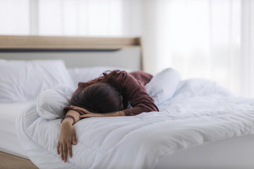 Asian woman is sleeping as a hangover from a party or asleep from exhaustion in her bed in the bedroom until the morning.