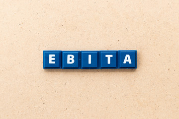 Tile letter in word EBITA (abbreviation of  earnings before interest, taxes and amortization) on wood background