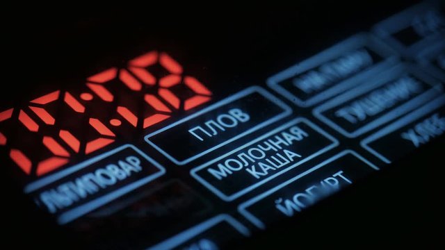 Digital screen of the Russian language multicooker with a choice of various programs close up view. Inscription in focus in the Russian language - "pilaf, milk porridge, yogurt".