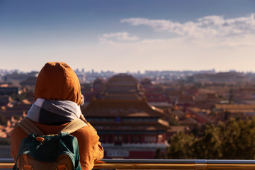 Tourist with blur view of the Forbidden City, Beijing, China from above with beautiful sky and beautiful warm evening light. This shot was taken at Jingshan park which is centre point of Beijing.