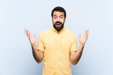 Fototapeta premium Young man with beard over isolated blue background with shocked facial expression