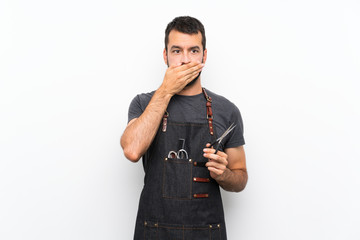 Barber man in an apron covering mouth with hands
